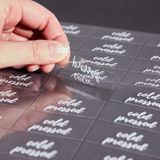 LABEL 2x1" PLASTIC CLEAR & WHT "COLD PRESSED" 100/cs